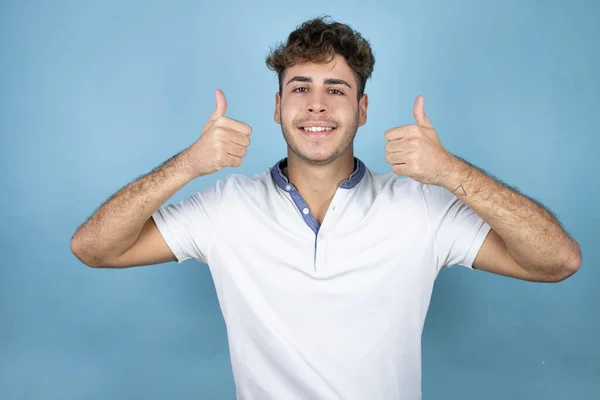 Joven Hombre Guapo Con Una Camiseta Blanca Sobre Fondo Azul —  Fotos de Stock