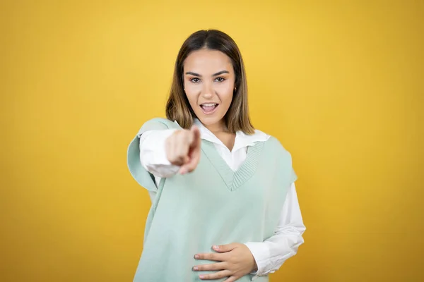 Mooie Jonge Vrouw Staat Gele Achtergrond Lachen Naar Wijzende Vinger — Stockfoto