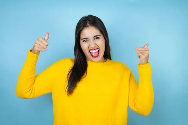 Jovem Mulher Bonita Vestindo Suéter Amarelo Sobre Fundo Azul Isolado — Fotografia de Stock