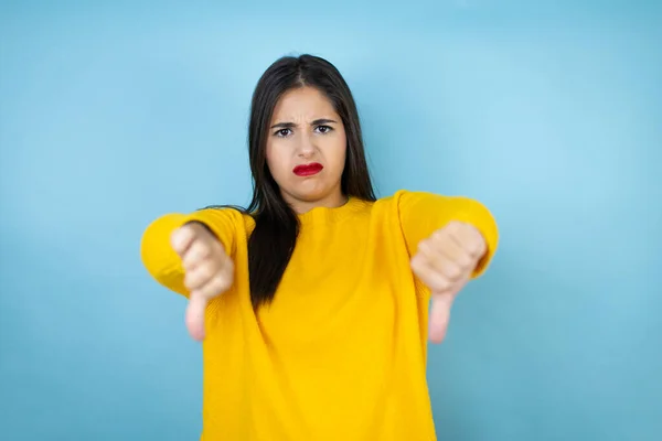 Jovem Mulher Bonita Vestindo Suéter Amarelo Sobre Fundo Azul Isolado — Fotografia de Stock