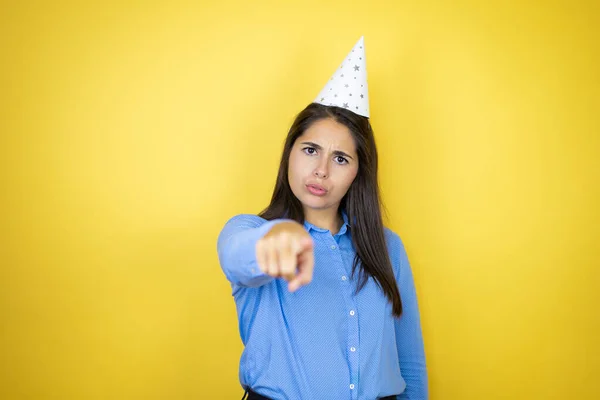 Jonge Blanke Vrouw Met Een Verjaardagshoed Geïsoleerde Gele Achtergrond Wijzend — Stockfoto