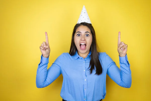Jonge Blanke Vrouw Met Een Verjaardagshoed Geïsoleerde Gele Achtergrond Verbaasd — Stockfoto