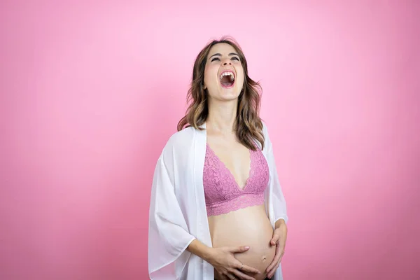 孤立したピンクの背景に赤ん坊を期待している若い美しいブルネットの女性は怒りで叫んで フラストレーションと激怒を叫びました 怒りと攻撃的な考え方 — ストック写真