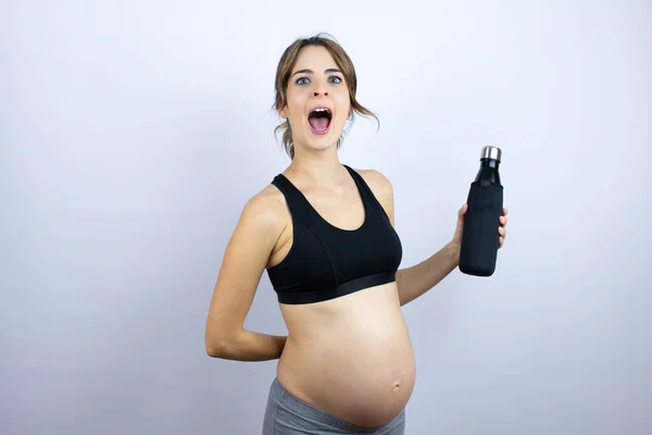 Młoda Kobieta Sportowa Ciąży Odzieży Sportowej Trzymająca Butelkę Wodą Białym — Zdjęcie stockowe