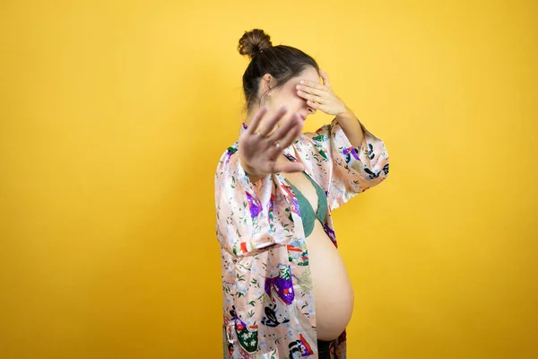 Junge Schöne Frau Schwanger Baby Trägt Pyjama Über Isolierten Gelben — Stockfoto