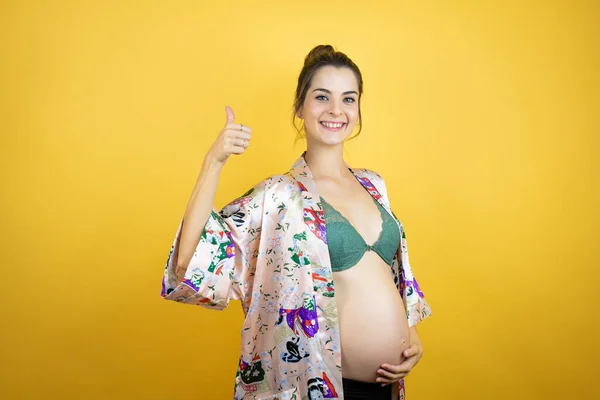 Ung Smuk Kvinde Gravid Forventer Baby Iført Pyjamas Isoleret Gul - Stock-foto