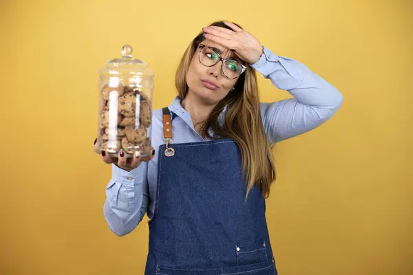 Young Hispanic Woman Wearing Baker Uniform Holding Cookies Jar Touching — Stock Photo, Image