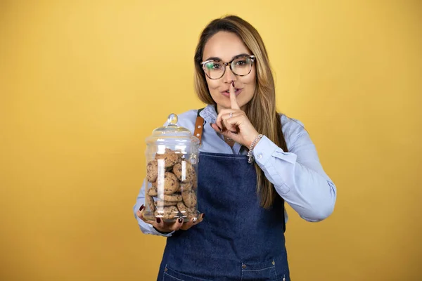 Young Hispanic Woman Wearing Baker Uniform Holding Cookies Jar Asking — Stock Photo, Image