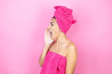 Banyodan sonra duş havlusu giyen genç ve güzel bir kadın izole edilmiş pembe arka planda durup avazın çıktığı kadar bağırıyor ve çığlık çığlığa bağırıyordu.