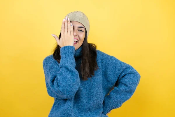 Młoda Piękna Kobieta Ubrana Niebieski Sweter Wełniany Kapelusz Zakrywający Jedno — Zdjęcie stockowe