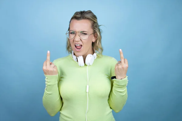 Young Caucasian Woman Wearing Headphones Neck Blue Background Showing Middle — Φωτογραφία Αρχείου