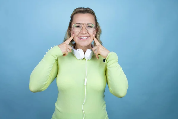 Mulher Branca Jovem Usando Fones Ouvido Pescoço Sobre Fundo Azul — Fotografia de Stock