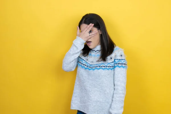 Młoda Biała Kobieta Ubrana Luźny Sweter Żółtym Tle Podglądająca Dłońmi — Zdjęcie stockowe