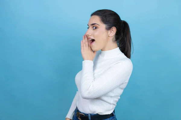 Jonge Blanke Vrouw Draagt Witte Trui Blauwe Achtergrond Hand Mond — Stockfoto