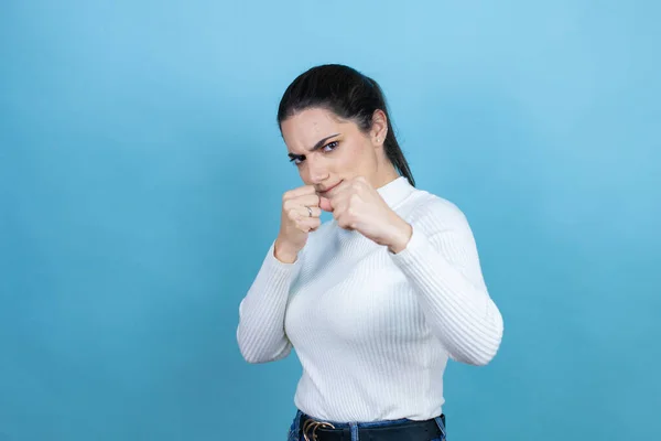 Jonge Blanke Vrouw Draagt Witte Trui Blauwe Achtergrond Slaan Vuist — Stockfoto