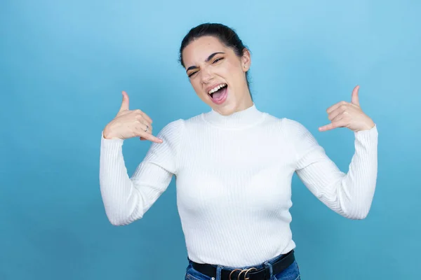 Joven Mujer Caucásica Usando Suéter Blanco Sobre Fondo Azul Gritando —  Fotos de Stock