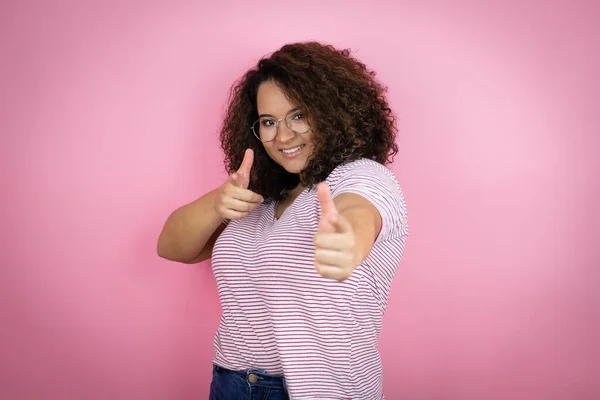 Joven Mujer Afroamericana Vistiendo Camisetas Rayas Rojas Sobre Fondo Rosa —  Fotos de Stock