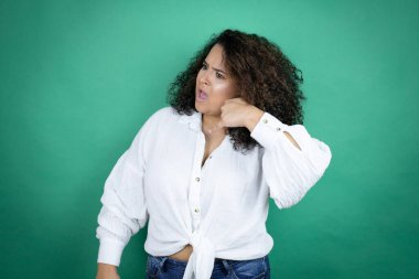 Beyaz tişörtlü, yeşil arka planda genç Afro-Amerikan kızı telefon hareketlerini telefonla konuşmak gibi karıştırıyor.