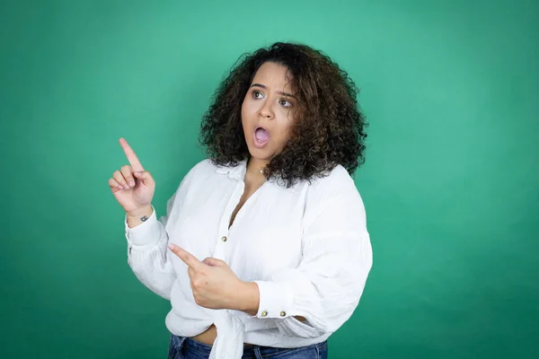 Joven Afroamericana Americana Con Camisa Blanca Sobre Fondo Verde Sorprendida —  Fotos de Stock