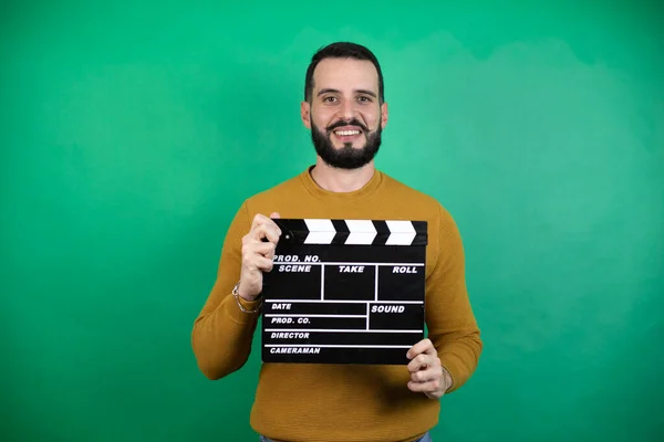 Bonito Homem Vestindo Roupas Casuais Sobre Isolado Fundo Verde Segurando — Fotografia de Stock