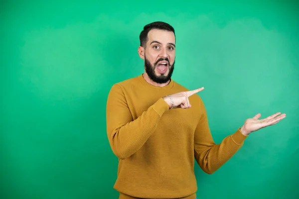 Knappe Man Draagt Casual Kleding Geïsoleerde Groene Achtergrond Verrast Tonen — Stockfoto