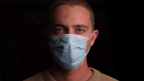 Triste hombre usando una máscara quirúrgica — Vídeos de Stock