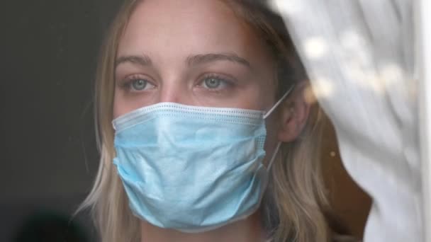 Frau in Quarantäne schaut aus dem Fenster — Stockvideo