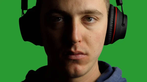 Young Man Wearing Headphones Looking at Camera, Green SCreen Background — Stockfoto