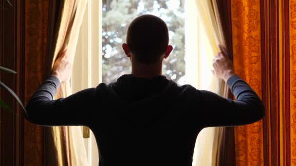 Rear View of a Man with Standing and Drawing the Curtains at Home, Quarantine Lockdown — Vídeos de Stock