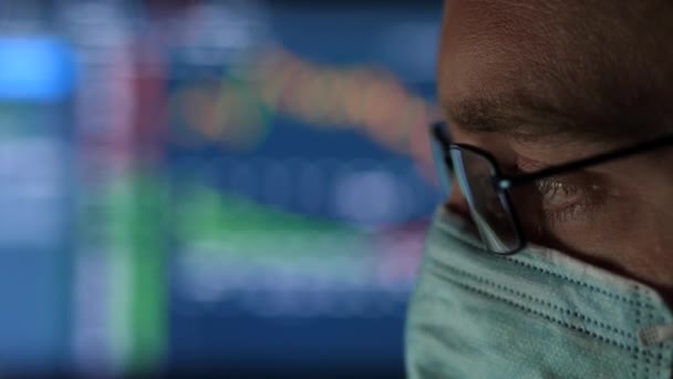 Hombre de negocios con una máscara quirúrgica trabajando en su computadora — Vídeos de Stock
