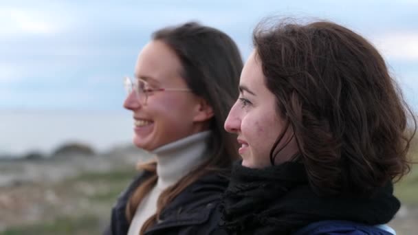 Junge lesbische Frauen genießen den Sonnenuntergang auf See — Stockvideo