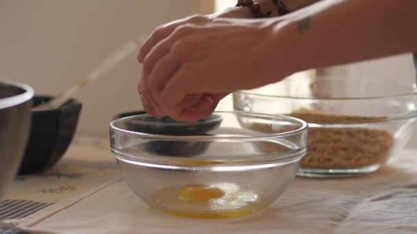 Женщина разбивает яйцо, медленное движение — стоковое видео