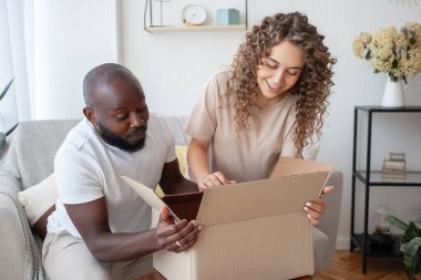 Mutlu çift duygusal olarak kutunun içine bakar, online mağazadan bir hediye açmak isterler. Karı ve koca hızlı doğum karşısında hayrete düşerler. Aile, alışveriş ve teslimat konsepti.