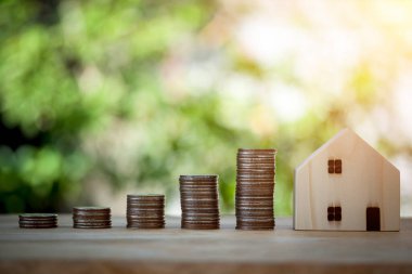 Madeni para yığını ve ev modeli büyüme için adım para tasarrufu, tasarruf konsepti için ipotek, gelecekte ev ve iş inşa.