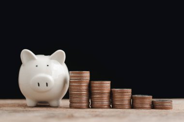 Tasarruf ve işletme finansal konsepti, beyaz domuz bankası ve para yığını para tutmak için adım göstermek için grafik gibi görünüyor, siyah arka planda gelecek planı.