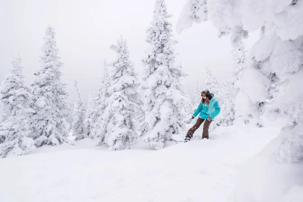 スノーボードで冬の雪の上に乗ってスノーボーダーの女性はスノーボードで斜面をカウルした パウダーデー スキー場での冬の休日 — ストック写真