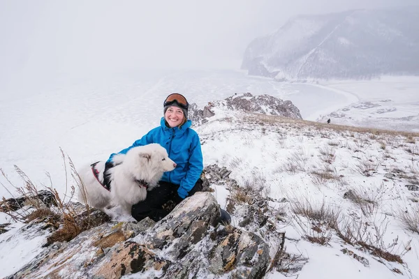 Портрет Туристки Стоящей Краю Скалы Над Замерзшим Морем Белой Собакой Стоковая Картинка