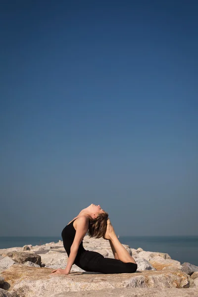 Kadın plajda yoga yapıyor. — Stok fotoğraf