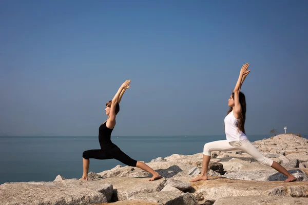 Kvinder, der praktiserer yoga på stranden - Stock-foto