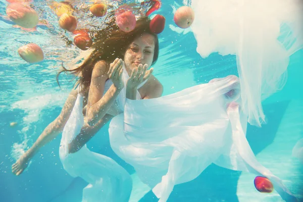 Mujer con bajo el agua con manzana roja — Foto de Stock