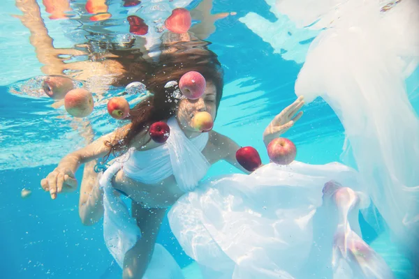 Woman with under water with red apple — Stock Photo, Image