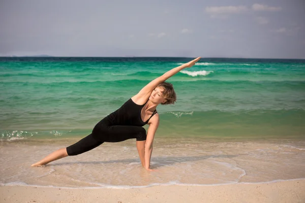 Sahilde kadın pratik yoga — Stok fotoğraf