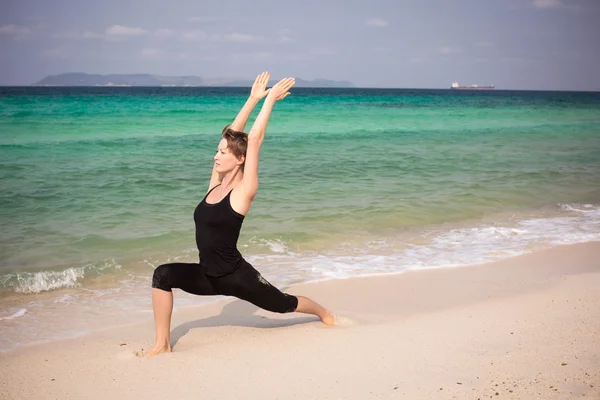 Žena cvičí jógu na pláži — Stock fotografie