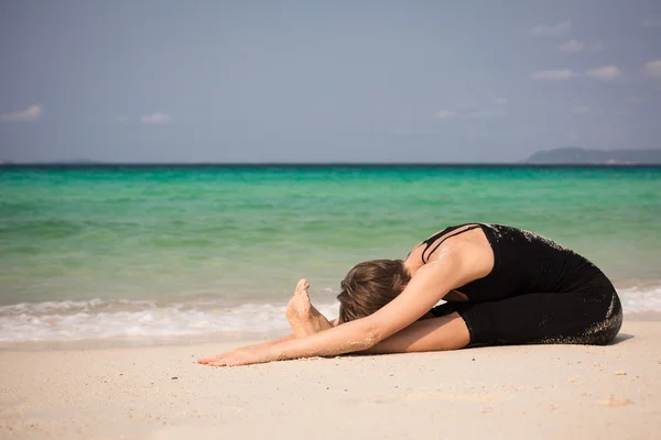 Mujer practicando Yoga en la playa — Foto de Stock