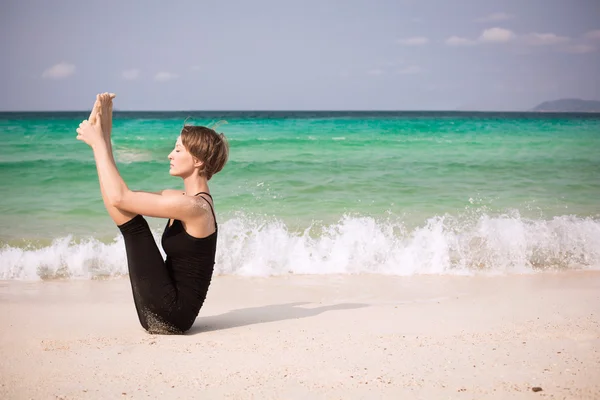 Woman practicing yoga on beach — Stock Photo, Image