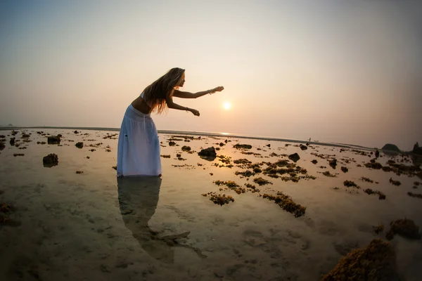 Donna sta ballando sulla spiaggia al tramonto — Foto Stock