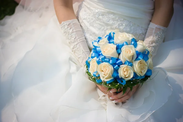 Novia en vestido de novia sostiene flores — Foto de Stock