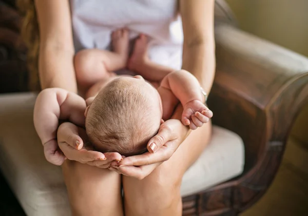 Mãe segurando cabeça de bebê recém-nascido — Fotografia de Stock