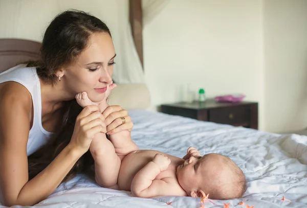 Mère avec un bébé jouant au lit — Photo