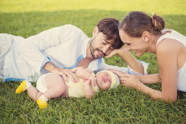 Moeder, vader en pasgeboren baby in een weide — Stockfoto